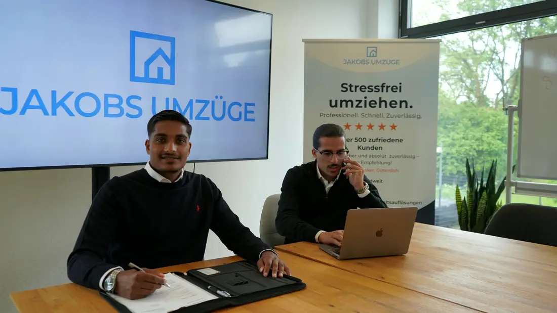 Das Team von Jakobs Umzüge im Büro — im Hintergrund Logo und Firmenbanner